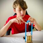 Young person building StemWizz wooden elevator STEM kit step by step